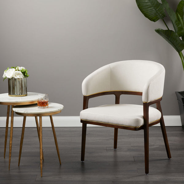 A fresh take on the traditional accent chair with soft ivory linen upholstered curves, Ash wood legs with walnut finish and  Polished gold trim