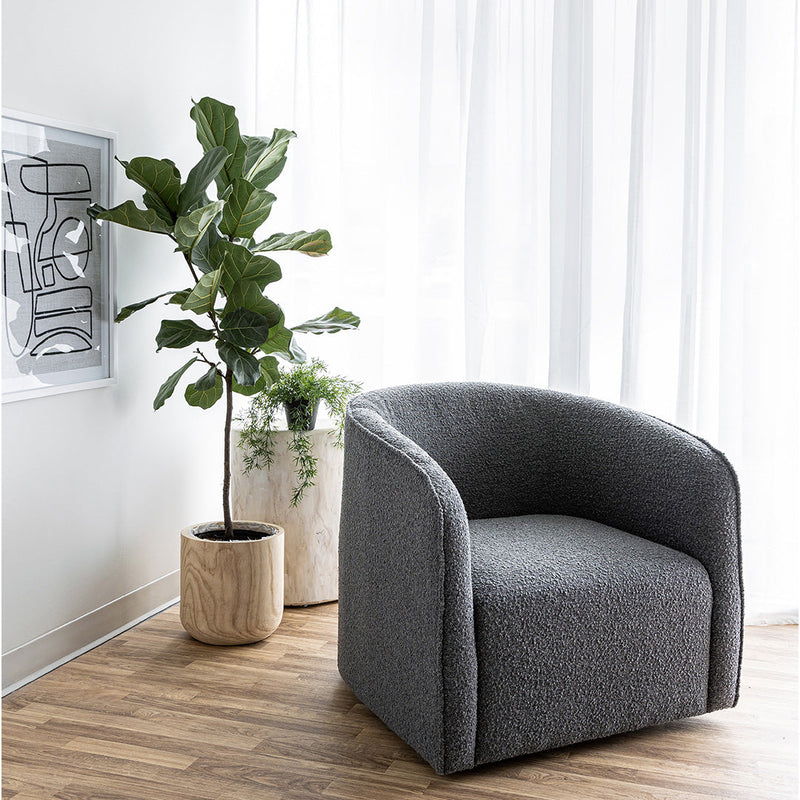  The Evita Swivel Chair in slate grey boucle. Its low profile makes it ideal for placement in a bedroom corner, a cozy reading nook, or as the perfect complement to your living room seating. Crafted in Europe and upholstered in a luxe boucle fabric, this barrel chair not only exudes sophistication but also boasts a hidden swivel base, allowing for subtle rotations around the room. Experience both style and functionality with this chic swivel chair designed to elevate the ambiance of any space in your home.